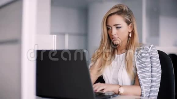 快乐的女商人在办公室里用笔记本电脑工作视频的预览图