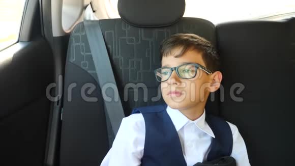 那个悲伤的男孩穿着校服坐在车里4k慢镜头视频的预览图