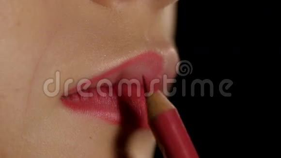 化妆师应用唇衬来模拟嘴唇黑色的特写视频的预览图