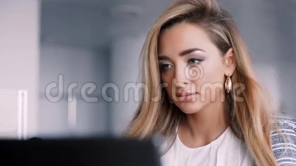 快乐的女商人在办公室里用笔记本电脑工作视频的预览图