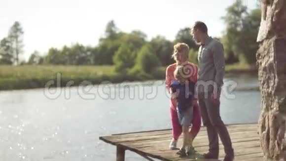 年轻的父母和儿子在池塘边视频的预览图
