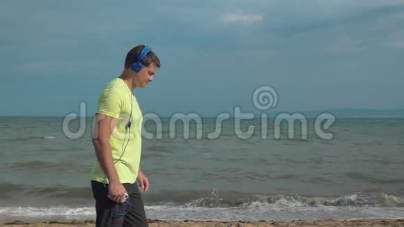男子在沙滩上用智能手机慢跑视频的预览图