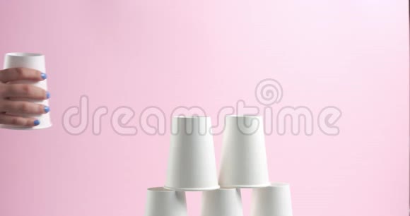 粉红色背景的白色纸杯制成的塔视频的预览图