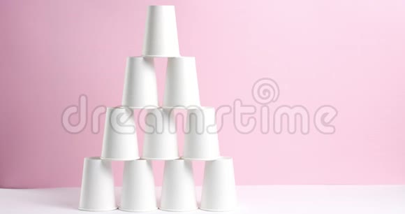 粉红色背景的白色纸杯制成的塔视频的预览图