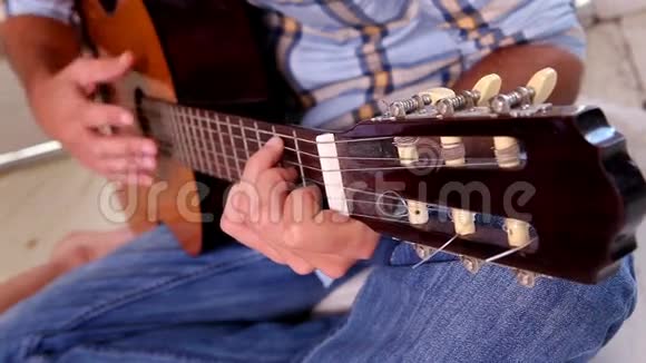 穿牛仔裤的男人弹吉他的衬衫视频的预览图