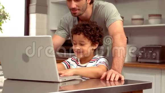 带着儿子在电脑上笑西班牙裔父亲视频的预览图