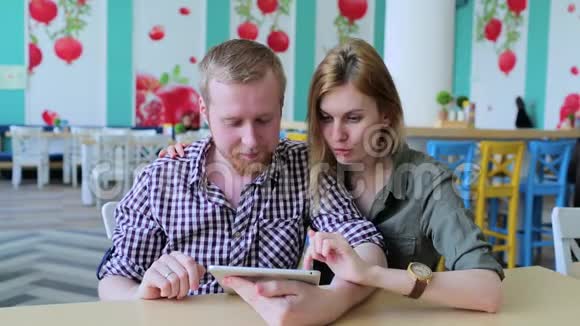 一对夫妇在咖啡馆里用平板电脑视频的预览图