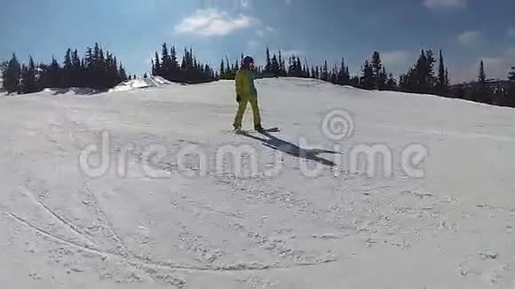 阳光明媚的一天一个滑雪板上的家伙滑下山坡视频的预览图