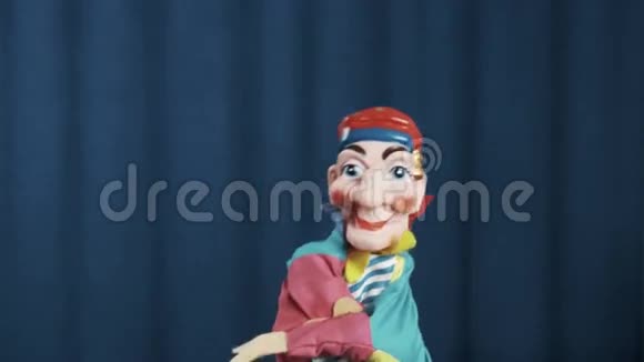 petrushka手木偶在现场用蓝色背景做抛钱动作视频的预览图