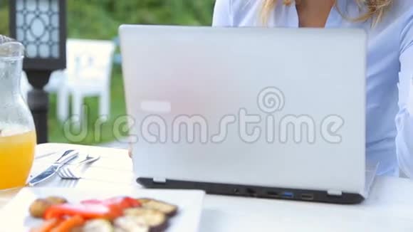 咖啡馆里的年轻女子使用笔记本电脑和信用卡上网购物视频的预览图
