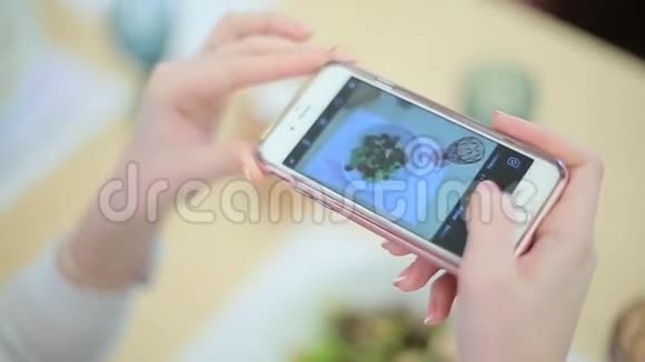 女孩在智能手机上拍照食物视频的预览图