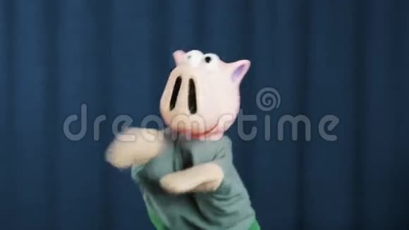 猪手木偶做现金抛掷手势在蓝色背景下环顾四周视频的预览图
