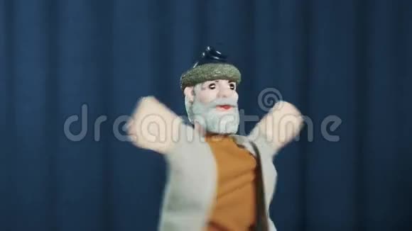 老人手偶在现场用蓝色背景做表情手掌视频的预览图
