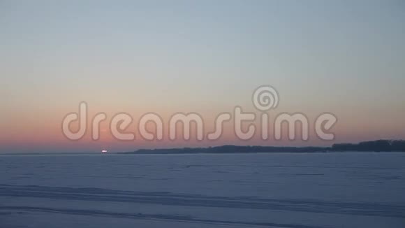 冬天的日落笼罩着一条冰冻的河流视频的预览图