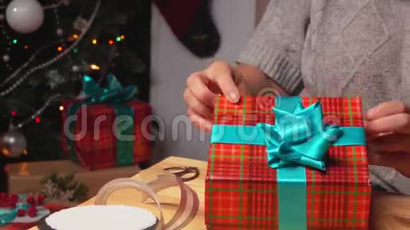 双手把包装好的礼物放在圣诞树下视频的预览图