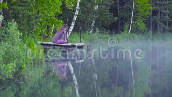 在湖岸做瑜伽运动的女人视频的预览图