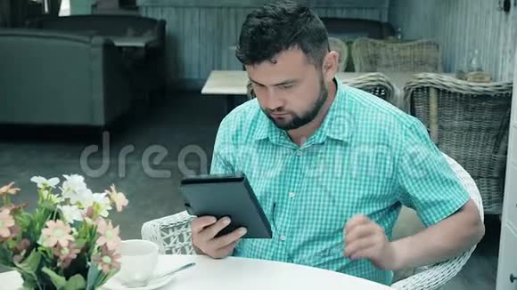 年轻商人读平板电脑新闻在办公室喝咖啡视频的预览图