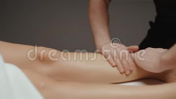 在水疗中心接受健康身体按摩的妇女按摩师做腿部按摩视频的预览图