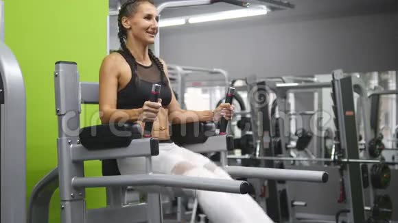 年轻强壮的女人穿着运动服在健身房锻炼腹部女子训练抬腿视频的预览图