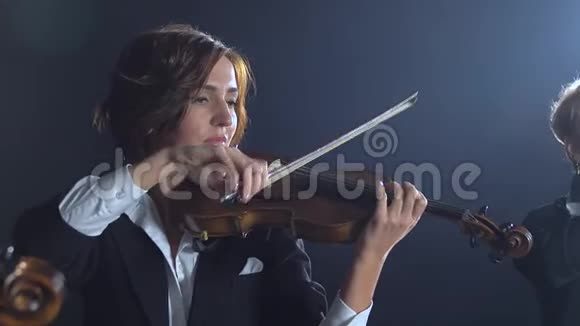 女孩们在房间里演奏小提琴黑烟背景视频的预览图