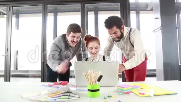 红发女人和男同事讨论笔记本电脑的新想法视频的预览图