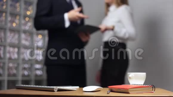 办公室桌上的文件和背景中的男女谈话视频的预览图