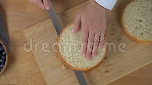 女人的手把饼干切成层顶部视图视频的预览图