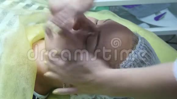 美容师双手抚摸客户的脸面部按摩美女一位美女的肖像视频的预览图