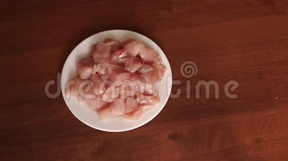 生鸡肉放在白盘上特写慢慢视频的预览图