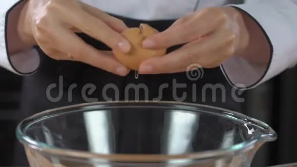 女人的手把鸡蛋打碎成玻璃碗视频的预览图