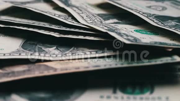 许多小的美元钞票随风摇摆在桌子上白色背景的宏观特写视频的预览图