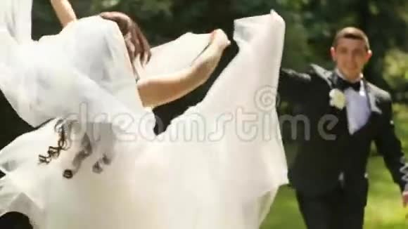 新婚夫妇新娘和新郎一起摆姿势玩得开心优雅的新郎戴着婚纱他们都笑了视频的预览图
