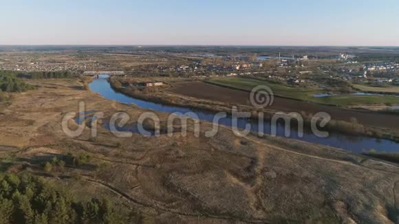 飞行上方绿地森林河流和村庄早春空中全景视频的预览图