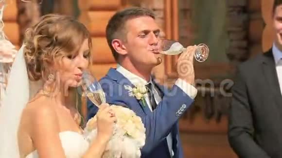 新婚快乐的新娘和新郎在婚礼上喝香槟视频的预览图