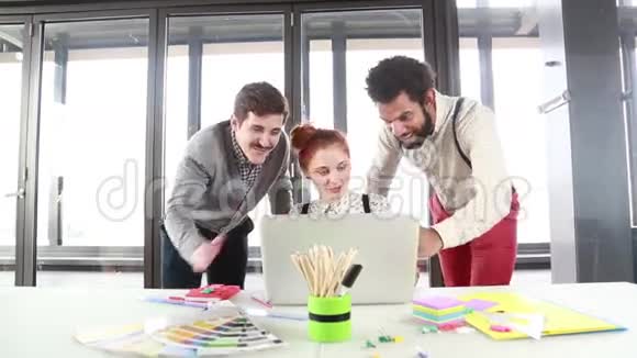 红发女人和男同事讨论笔记本电脑的新想法视频的预览图