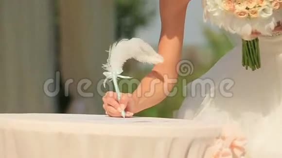 新郎新娘拿笔签结婚证书视频的预览图
