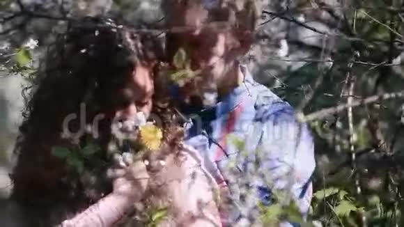 一对浪漫的夫妇在盛开的樱桃园开着许多白花帅哥拥抱梦幻女孩视频的预览图