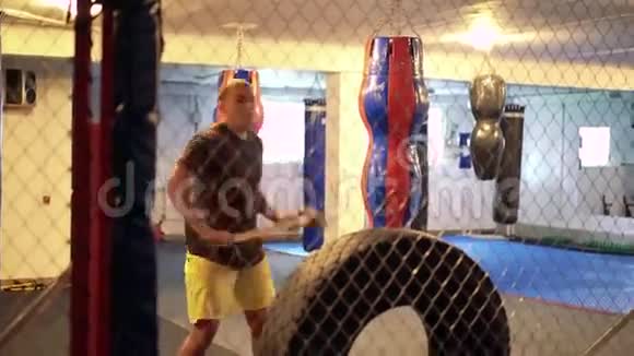 运动员在健身房的笼子里用悍马和轮胎做运动4k视频的预览图