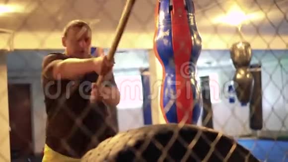 拳击手在健身房的笼子里用悍马和轮胎做运动4k视频的预览图