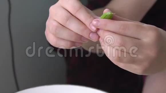 年轻的手在碗里剥青豌豆视频的预览图