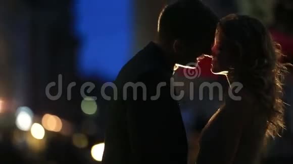 爱的一对情侣在欧洲城市的晚街谈论雨年轻人试图亲吻贪玩的女人视频的预览图