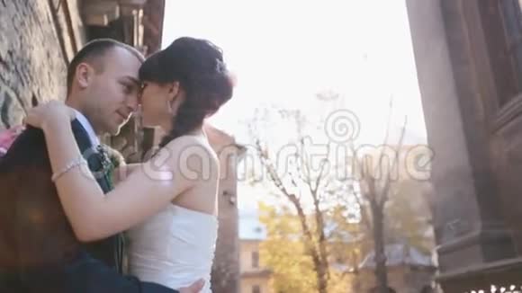 年轻的新婚夫妇在布拉格老城的旧墙附近接吻低角度视野视频的预览图