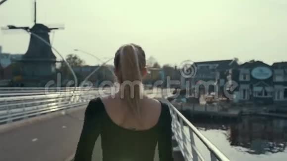 在荷兰的一座桥上一个女性的轮廓在日落时奔跑动作缓慢视频的预览图