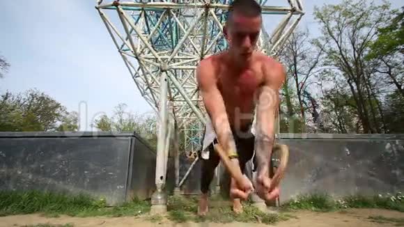 肌肉发达的男人用体操圈做俯卧撑视频的预览图