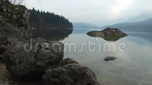 4K令人惊叹的博欣吉湖景观通过树木树枝朱利安阿尔卑斯山特里格拉夫国家公园斯洛文尼亚欧洲冬季视频的预览图