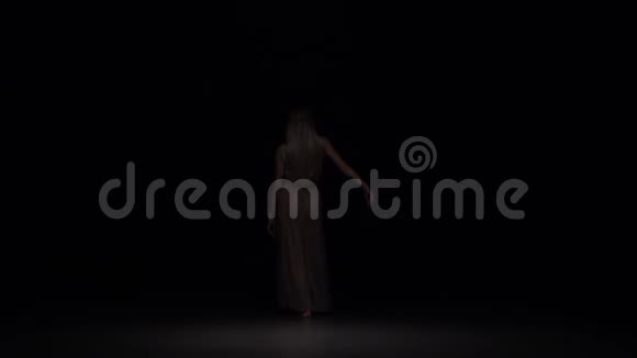 在黑暗的背景下在暮色中表现出轻蔑的女性慢动作视频的预览图