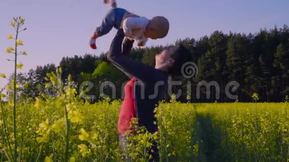 妈妈在油菜田里和宝宝玩扔了慢动作视频的预览图