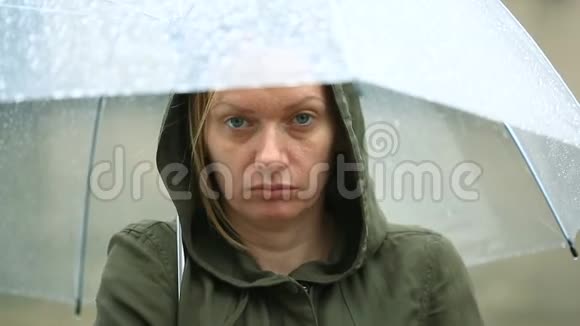 受天气影响雨中伞下站立不快乐的女人视频的预览图