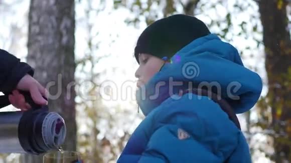 这孩子正在冬天的户外喝杯热茶晴天视频的预览图