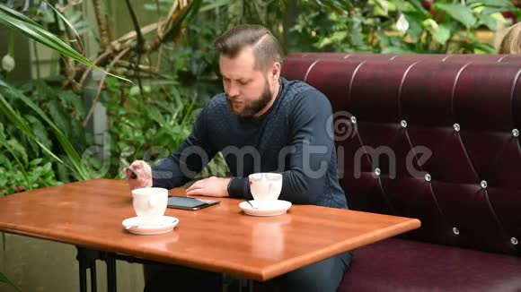 商人坐在咖啡馆里打电话喝咖啡在咖啡馆里忙碌的人和朋友聊天视频的预览图
